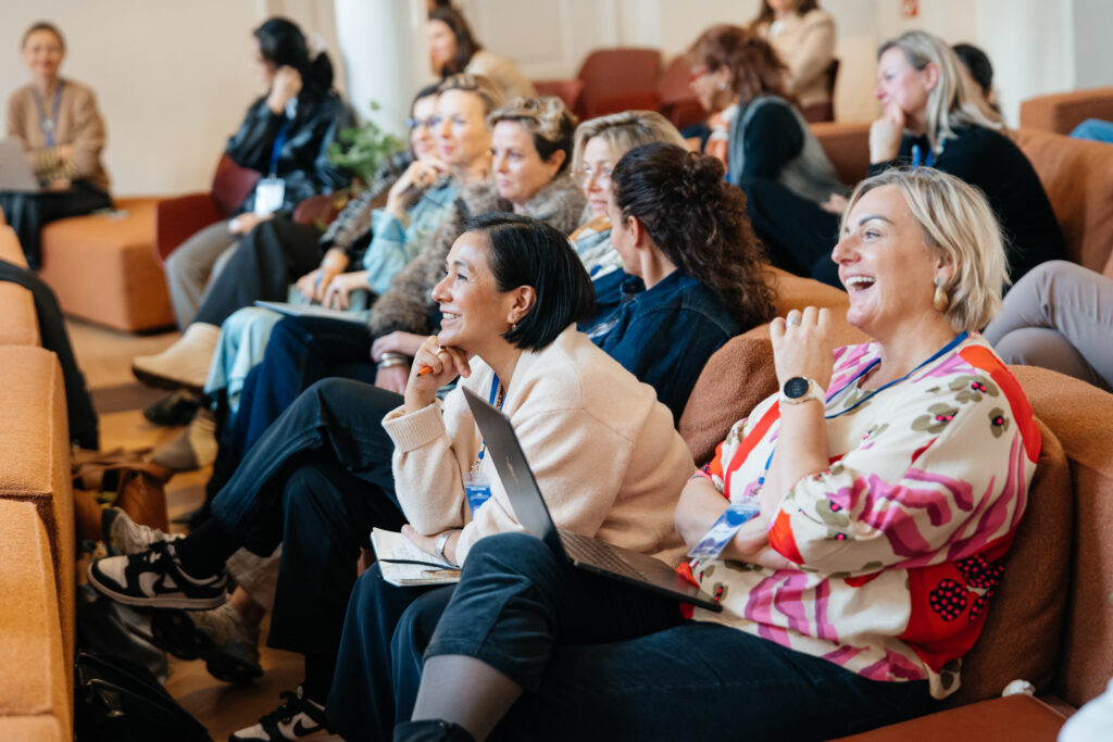 group of women laughing and chatting while sitting in a room